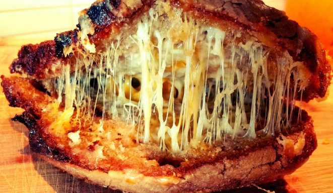 The Press & Melt cheese pull Melted cheese stretching between two halves of a Press & Melt toastie